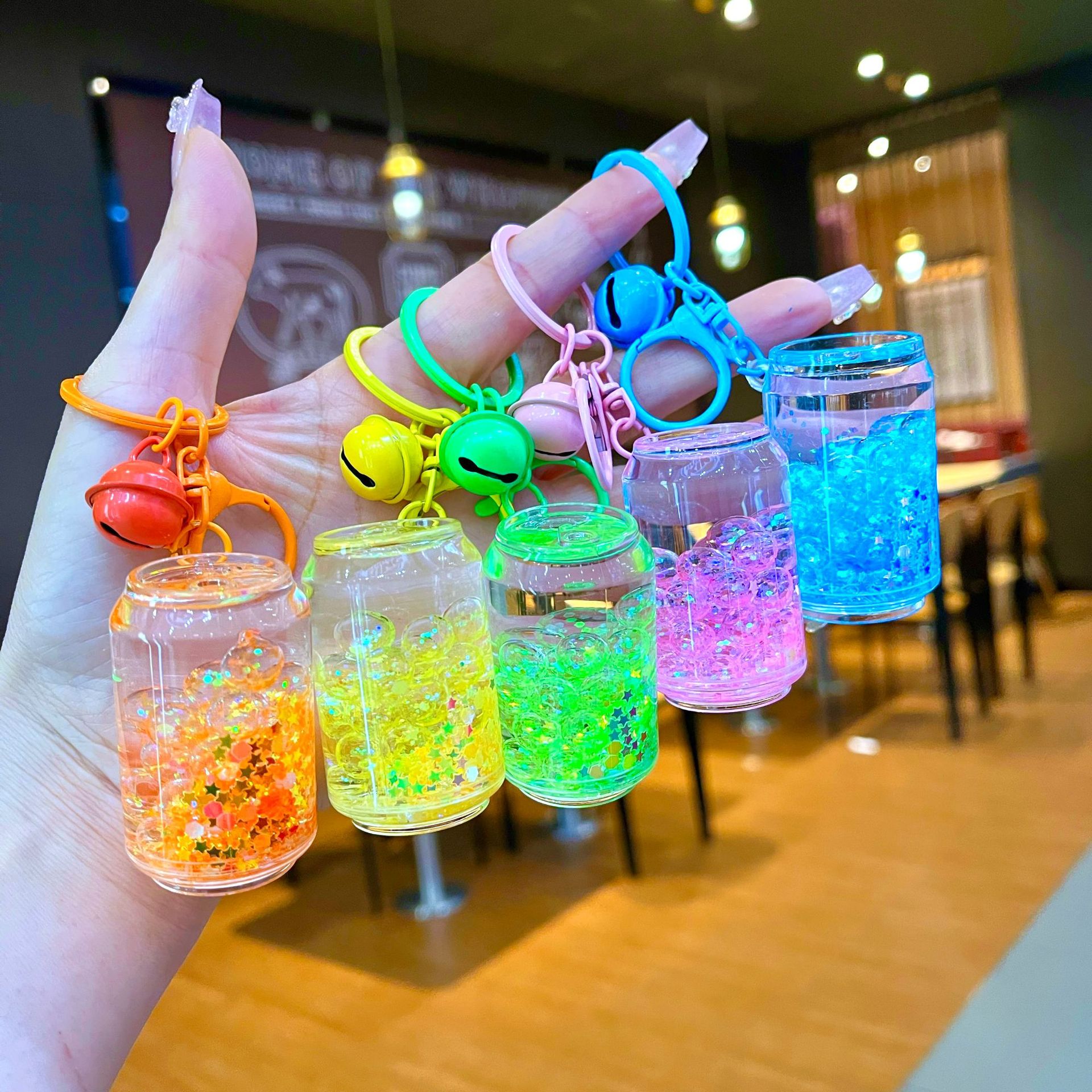 Shake sound, pop coke bottle, color bead, luminous key chain, oil pop can, quicksand pendant, gift toys and ornaments